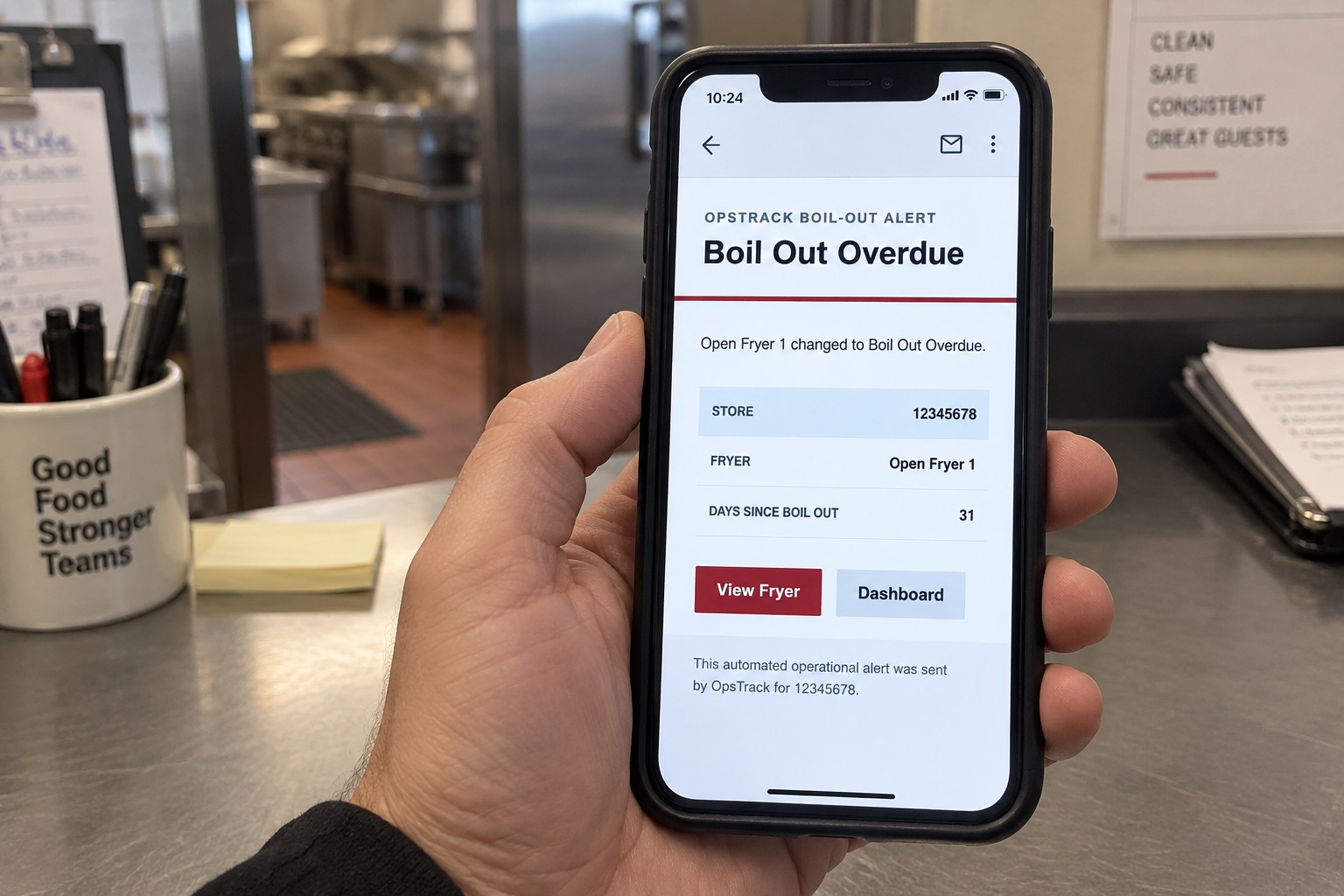Illustrative scene of an OpsTrack overdue boil-out email on a phone with View Fryer and Dashboard buttons.